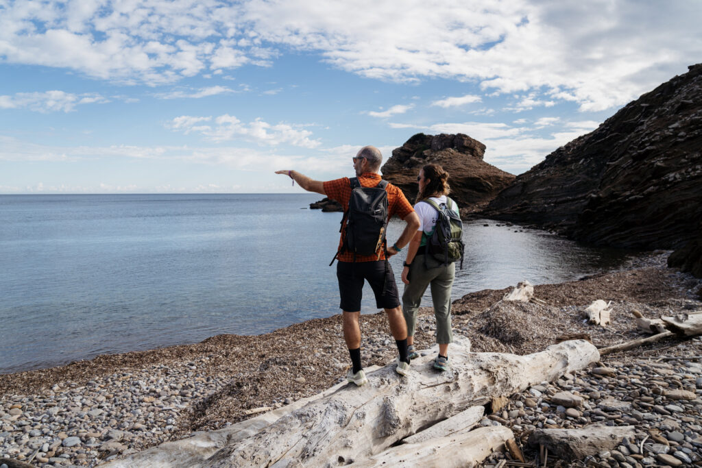 Dos senderistes admiren el paisatge d'una mar en calma (Foto: Camí de Cavalls 360º).