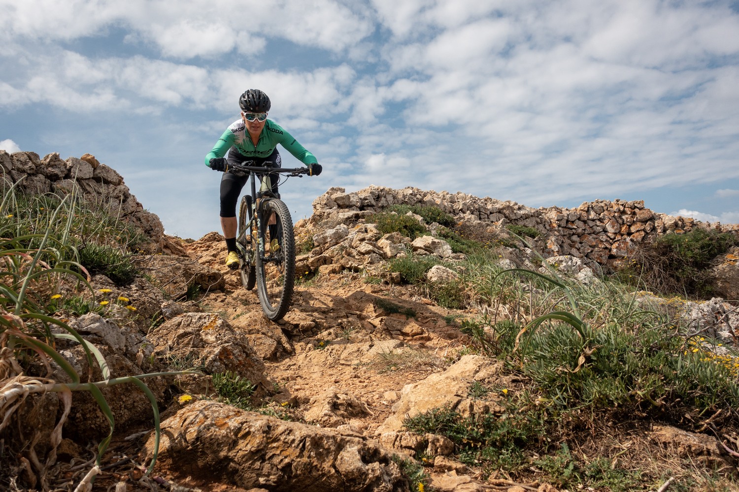Una ciclista baixa entre pedres (Foto: Camí de Cavalls 360º).